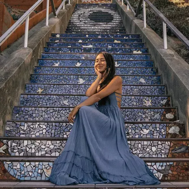 Uma mulher posa sentada nas escadas de azulejos da 16th Avenue, no bairro Sunset, em São Francisco.